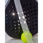 Protector ShockSkin translúcido sobre el canto de una pala de pádel con pelota, pala no incluida, Shockout